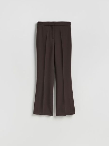 Spodnie z rozcięciem - ciemnobrązowy. Brązowe spodnie materiałowe damskie Reserved, bez wzorów, z tkaniny. Za 119.99 zł.