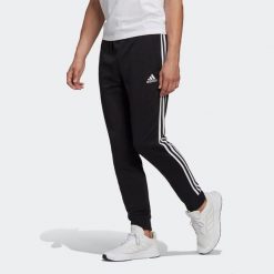 Spodnie adidas Essentials French Terry Tapered Cuff 3-Bandes. Białe spodnie sportowe męskie Adidas, m, bez wzorów, z bawełny, na fitness i siłownię. Za 163.99 zł.