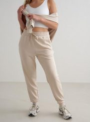 Damskie spodnie dresowe regular fit, ściągacze Comfy Modal beżowe. Białe spodnie dresowe damskie Aim'n, xl, bez wzorów, z dresówki. Za 339.00 zł.