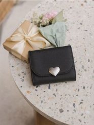 Mały portfel z ozdobnym zapięciem w kształcie serca - czarny. Czarne portfele damskie Sinsay, bez wzorów. Za 29.99 zł.