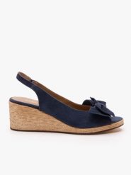 Granatowe sandały na koturnie z kokardą. Niebieskie sandały damskie Ryłko, bez wzorów, ze skóry, bez obcasa, na koturnie, bez zapięcia. Za 399.99 zł.