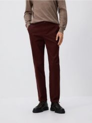 Bawełniane spodnie chino slim - mahoniowy. Brązowe spodnie materiałowe męskie Reserved, bez wzorów, z bawełny. Za 129.99 zł.