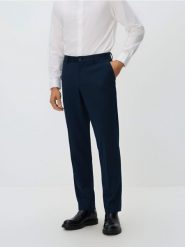 Garniturowe spodnie slim fit - granatowy. Niebieskie eleganckie spodnie męskie Reserved, l, bez wzorów, z dzianiny. Za 149.99 zł.