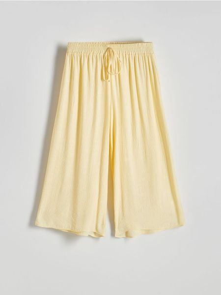 Spodnie culotte z wiskozy - jasnożółty. Żółte spodnie materiałowe damskie Reserved, l, bez wzorów, z tkaniny. W wyprzedaży za 59.99 zł.