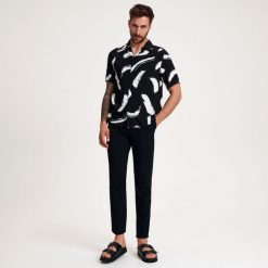 Spodnie chino slim z kantem - czarny. Czarne spodnie materiałowe męskie Reserved, bez wzorów, z tkaniny. W wyprzedaży za 99.99 zł.