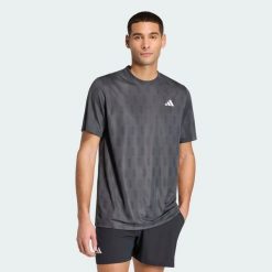 KOSZULKA CLUB TENNIS CLIMACOOL GRAPHIC. Czarne koszulki sportowe męskie Adidas, l, bez wzorów, z materiału, bez kołnierzyka, bez ramiączek, na fitness i siłownię, climacool (adidas). Za 179.00 zł.