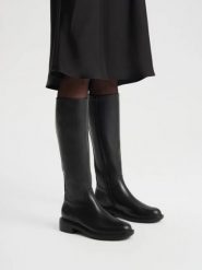 Eleganckie czarne kozaki z wąską cholewką. Czarne kozaki damskie Ryłko, z gumy, z okrągłym noskiem, bez obcasa, na obcasie. Za 699.99 zł.