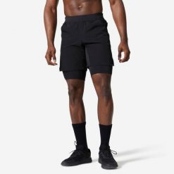 Spodenki fitness cardio męskie Domyos 2w1. Czarne krótkie spodenki sportowe męskie DOMYOS, m, bez wzorów, z elastanu, na fitness i siłownię. Za 89.99 zł.