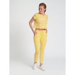 Damska koszulka crop top Hummel Legacy. Żółte koszulki sportowe damskie Hummel, l, bez wzorów, bez kołnierzyka, bez ramiączek. Za 91.50 zł.