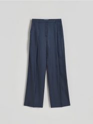 Spodnie z połyskującej tkaniny - granatowy. Niebieskie spodnie materiałowe damskie Reserved, l, bez wzorów, z tkaniny. W wyprzedaży za 69.99 zł.