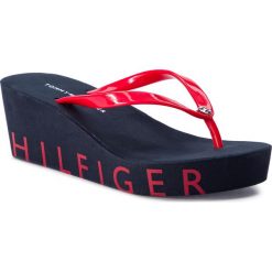 Japonki TOMMY HILFIGER - Wedge Beach Sandal FW0FW04057 Tango Red 611. Czerwone klapki damskie Tommy Hilfiger, bez wzorów, z tworzywa sztucznego, bez obcasa, na obcasie, bez zapięcia. W wyprzedaży za 139.00 zł.