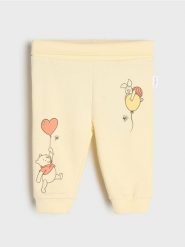 Spodnie dresowe jogger Winnie the Pooh - żółty. Żółte spodenki niemowlęce Sinsay, bez wzorów, z dresówki. Za 15.99 zł.