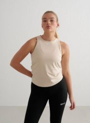 Damski top treningowy ultramiękki, szybkoschnący Soft Basic beżowy. Białe szorty męskie Aim'n, s, bez wzorów, z dzianiny, sportowe. Za 130.00 zł.