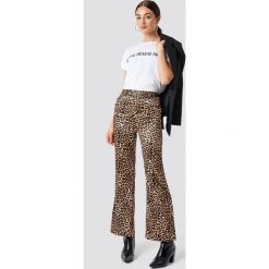 NA-KD Trend Spodnie Flared Shiny Leo - Brown. Spodnie materiałowe damskie marki NA-KD Trend. Za 141.95 zł.