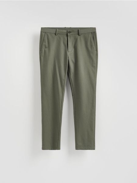 Spodnie chino slim fit - jasny zielony. Zielone spodnie materiałowe męskie Reserved, bez wzorów, z tkaniny. Za 159.99 zł.