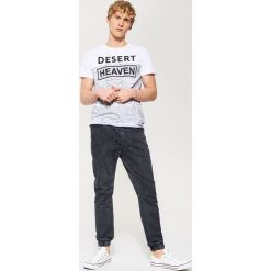 T-shirt z napisem - Biały. Białe t-shirty damskie House, l, bez wzorów, bez kołnierzyka. W wyprzedaży za 19.99 zł.