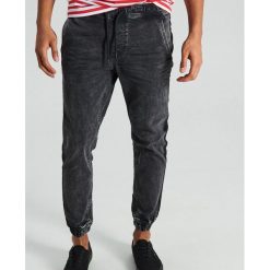 Jeansy slim jogger z materiałowym lampasem - Czarny. Jeansy męskie marki Cropp. Za 119.99 zł.