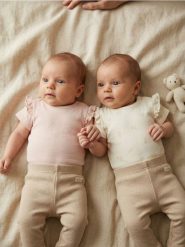 Bawełniane body z ozdobnymi falbanami 2 pack - kremowy. Białe body niemowlęce Sinsay, bez wzorów, z bawełny, bez ramiączek. Za 25.99 zł.