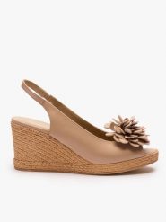 Beżowe sandały na koturnie z kwiatem. Brązowe sandały damskie Ryłko, bez wzorów, ze skóry, bez obcasa, na koturnie, bez zapięcia. Za 399.99 zł.