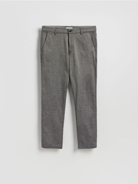 Spodnie chino slim fit - szary. Szare spodnie materiałowe męskie Reserved, bez wzorów, z bawełny. W wyprzedaży za 45.99 zł.