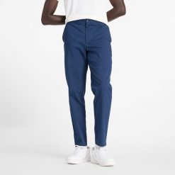 Spodnie męskie New Balance MP43554NNY – granatowe. Niebieskie spodnie materiałowe męskie New Balance, m, bez wzorów, z bawełny, klasyczne. Za 349.99 zł.