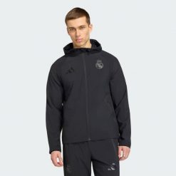 Wiatrówka Real Madryt Travel z suwakiem na całej długości. Czarne bluzy męskie Adidas, bez wzorów, z kapturem. Za 399.00 zł.