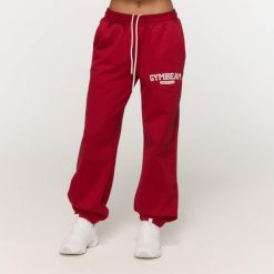 Spodnie dresowe damskie fitness oversize czerwone Varsity. Czerwone spodnie sportowe damskie GYMBEAM, xs, bez wzorów, z bawełny, na fitness i siłownię. Za 126.90 zł.