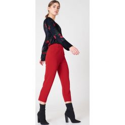 NA-KD Trend Spodnie z surowo wykończonymi nogawkami - Red. Spodnie materiałowe damskie marki NA-KD Trend. W wyprzedaży za 64.78 zł.