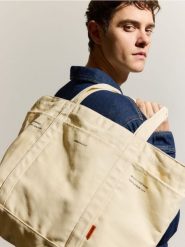 Materiałowa torba na ramię - złamana biel. Torby na ramię męskie Reserved, bez wzorów, z materiału, na ramię, małe. Za 69.99 zł.