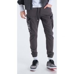 Elastyczne spodnie slim jogger - Szary. Spodnie materiałowe męskie marki Cropp. W wyprzedaży za 79.99 zł.