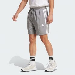 Szorty Essentials 3-Stripes Chelsea. Białe krótkie spodenki sportowe męskie Adidas, bez wzorów, z materiału, na fitness i siłownię. W wyprzedaży za 89.25 zł.