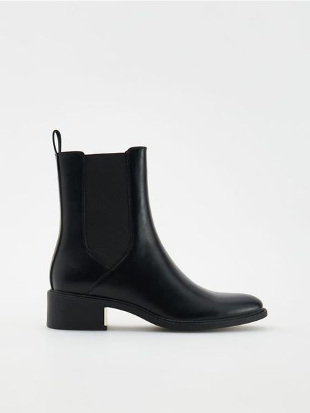 Botki z imitacji skóry - czarny. Czarne botki damskie Reserved, ze skóry, klasyczne, bez obcasa, bez zapięcia. Za 169.99 zł.