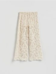 Ażurowe spodnie - kremowy. Białe spodnie materiałowe damskie Reserved, l, w ażurowe wzory, z bawełny. Za 199.99 zł.