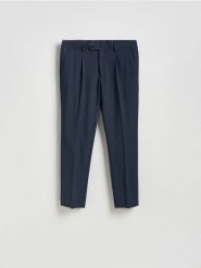 Spodnie garniturowe slim fit - granatowy. Niebieskie eleganckie spodnie męskie Reserved, bez wzorów, z elastanu. Za 169.99 zł.