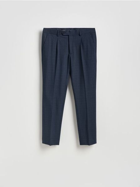 Spodnie garniturowe slim fit - granatowy. Niebieskie eleganckie spodnie męskie Reserved, l, bez wzorów, z elastanu. Za 169.99 zł.