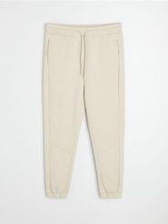 Spodnie tapered fit Active - kremowy. Białe spodnie sportowe męskie Sinsay, l, bez wzorów, na fitness i siłownię. Za 59.99 zł.