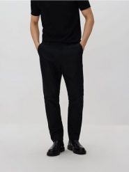 Spodnie chino slim fit - czarny. Czarne spodnie materiałowe męskie Reserved, bez wzorów, z tkaniny. Za 159.99 zł.