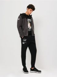Spodnie tapered fit NASA - czarny. Czarne spodnie materiałowe męskie Sinsay, l, bez wzorów. Za 59.99 zł.