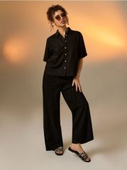 Klapki z motywem zebry ze skórzaną wkładką - czarny. Czarne klapki damskie Sinsay, bez wzorów, bez obcasa. Za 49.99 zł.