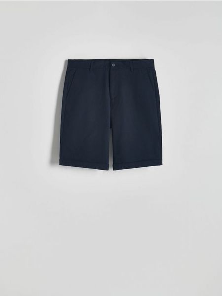 Szorty slim fit - granatowy. Niebieskie szorty męskie Reserved, bez wzorów, z bawełny. W wyprzedaży za 49.99 zł.