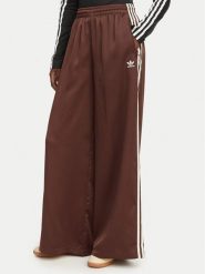 Adidas Spodnie dresowe adicolor Satin KD2541 Brązowy Wide Leg. Brązowe spodnie dresowe damskie Adidas, bez wzorów, z dresówki. Za 348.99 zł.