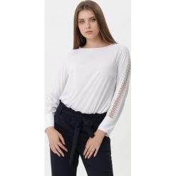 Biała Bluzka Jeanette. Białe bluzki damskie Born2be, l, w ażurowe wzory, z jeansu, eleganckie, bez kołnierzyka, bez ramiączek. Za 59.99 zł.