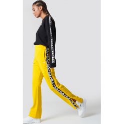 FILA Spodnie Thora Track - Yellow. Żółte spodnie materiałowe damskie Fila, w paski. Za 283.95 zł.