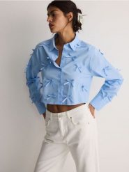 Krótka koszula z kokardkami - niebieski. Niebieskie koszule damskie Reserved, l, bez wzorów, z bawełny, bez kołnierzyka, bez ramiączek. W wyprzedaży za 65.99 zł.