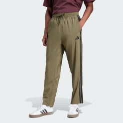 Spodnie Essentials 3-Stripes Stanford Open Hem. Brązowe buty sportowe męskie Adidas, z materiału, bez zapięcia, na fitness i siłownię. W wyprzedaży za 134.25 zł.