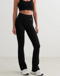 Damskie legginsy bezszwowe, prążkowane, wysoki stan, dzwony, długie, czarne. Czarne legginsy damskie Aim'n, m, bez wzorów, z elastanu, z podwyższonym stanem, długie, na fitness i siłownię. Za 301.00 zł.