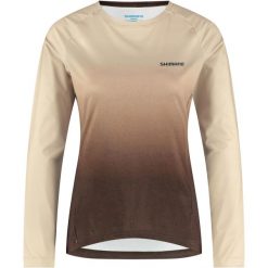 Ciepła koszulka damska SAIKO z długim rękawem i nadrukiem, Feather Beige. Brązowe bluzy sportowe damskie Shimano, bez wzorów, z dżerseju, bez kołnierzyka, bez ramiączek, rowerowe. Za 419.90 zł.