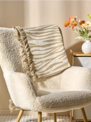 Koc wykończony frędzlami z motywem zwierzęcym - brązowy. Brązowe kocyki dla dzieci Sinsay. W wyprzedaży za 22.99 zł.