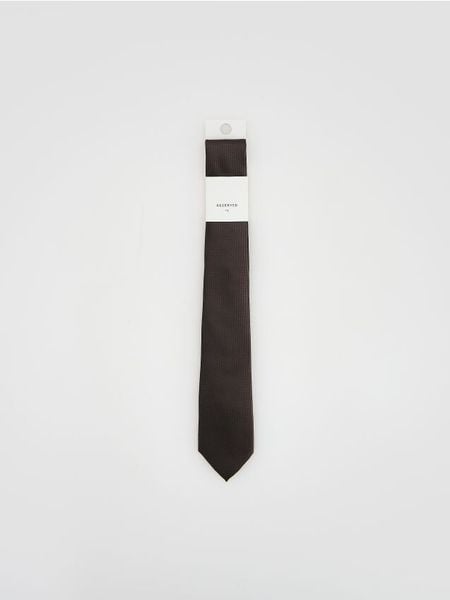Wąski krawat w drobny wzór - ciemnobrązowy. Brązowe krawaty i muchy Reserved, bez wzorów. Za 59.99 zł.