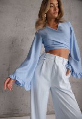 Niebieska Bluzka z Wiskozy z Kopertowym Dekoltem Wiązaniem i Falbankami Diomiopis. Niebieskie t-shirty i topy dla dziewczynek Renee, bez wzorów, z jeansu, bez ramiączek. Za 89.99 zł.